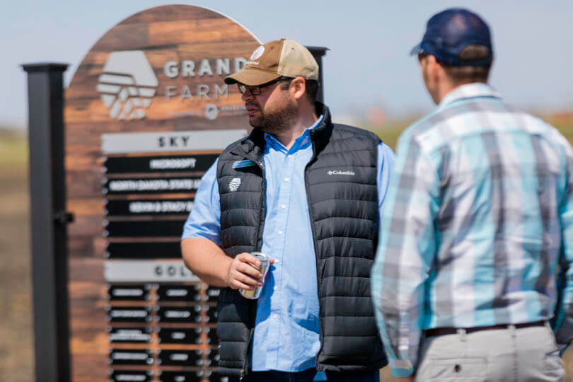 two people talk at Grand Farm event