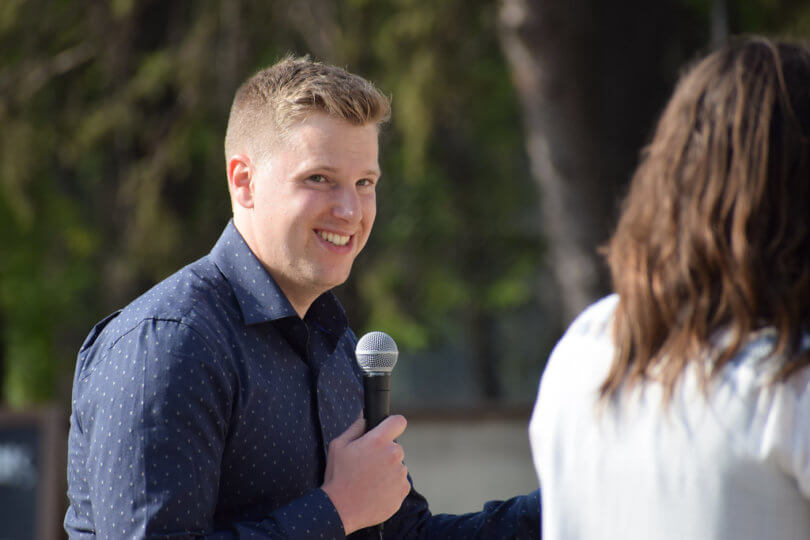 a speaker holds a microphone at Emerging Prairie Event